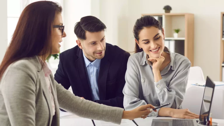 Coach professionnel expliquant une stratégie à deux City Manager de chez Comme My Home autour d’un ordinateur.